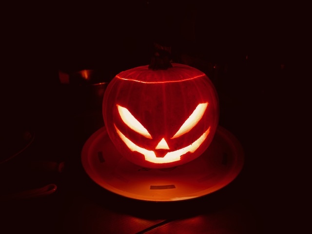 A traditional candle lit evil looking pumpkin in the dark.